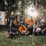 Pessoas reunidas com cães durante um evento de adoção em um parque