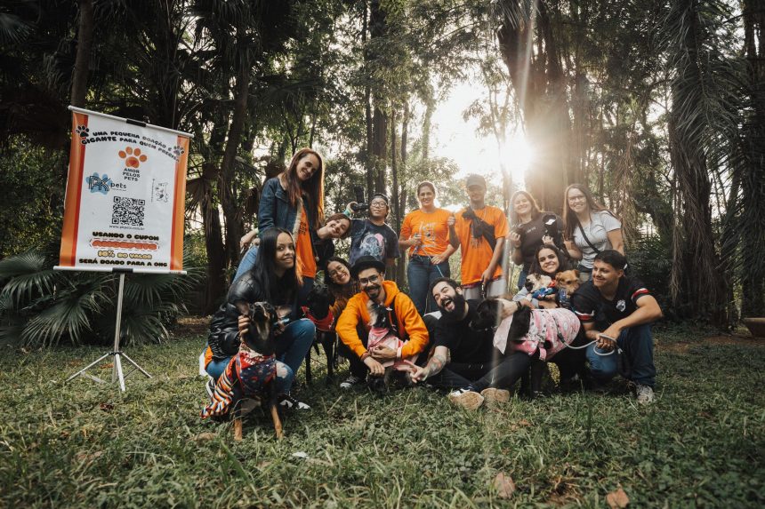 Pessoas reunidas com cães durante um evento de adoção em um parque