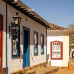 Rua histórica com casarões coloniais coloridos e calçamento de pedras.