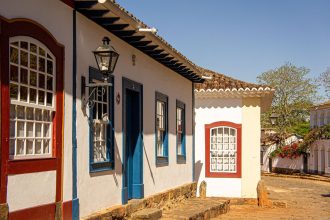 Rua histórica com casarões coloniais coloridos e calçamento de pedras.