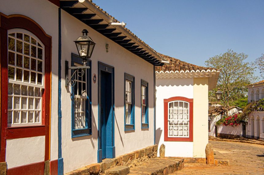 Rua histórica com casarões coloniais coloridos e calçamento de pedras.