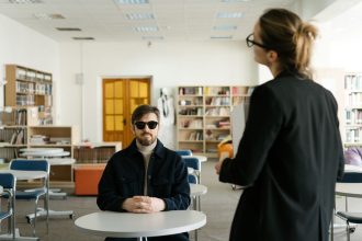 Estudante cego participa de uma atividade em sala de aula com a orientação da professora.
