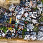 Vista aérea de um depósito de sucata com grandes pilhas de materiais metálicos.