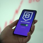 Mão segurando um smartphone com a tela de uma carteira de criptomoedas baseada em blockchain.