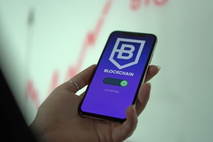 Mão segurando um smartphone com a tela de uma carteira de criptomoedas baseada em blockchain.