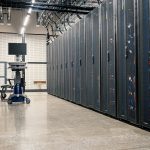 Armários metálicos com servidores, dispositivos de rede e cabos em um data center moderno