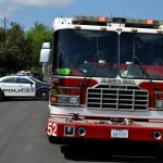 Viaturas da polícia e do Corpo de Bombeiros estacionadas juntas em uma área urbana.
