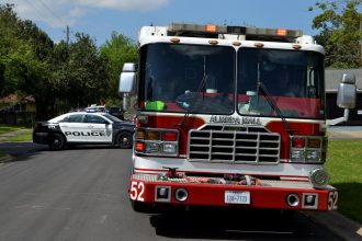 Viaturas da polícia e do Corpo de Bombeiros estacionadas juntas em uma área urbana.